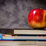 stack of books with apple on top